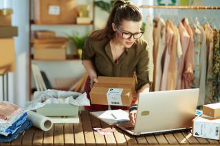 stylish small business owner woman using laptop in office