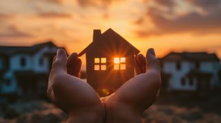 A conceptual background on home protection insurance, featuring hands holding a paper house